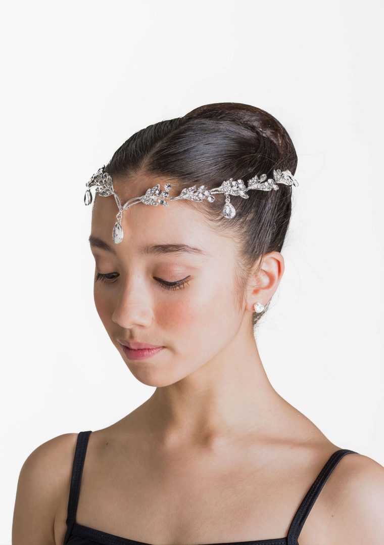 Large hairpiece on headband with droplet embellishments.